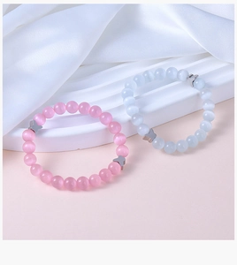 Detail of pink and blue cat eye stone beaded bracelets with silver butterfly charms