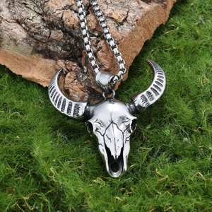 Vintage stainless steel ram skull pendant necklace on rustic wood and grass background