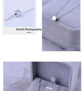 Macro shot of silver titanium necklace with brushed cube pendant and thin box chain details