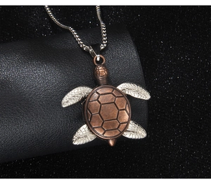 Detail of vintage turtle pendant with bronze shell and silver limbs on snake chain