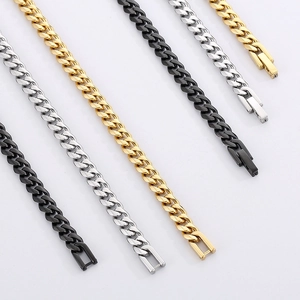 Flat lay of Cuban link necklaces in black, gold, and silver finishes on white background