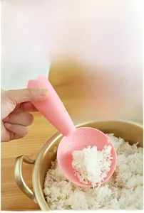 Pink rice paddle showing double-sided non-stick bumps during serving usage scenario
