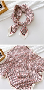 Detail of a square silk scarf with cream base and red-black geometric letter patterns