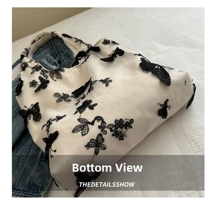 Detail of embroidered black butterflies on cream canvas bag with denim lining interior