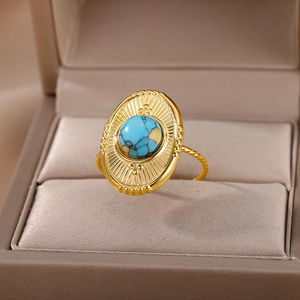 Detail of vintage gold ring with turquoise stone and twisted band on jewelry box