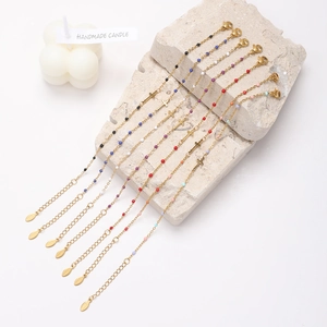 Detail of colorful beads and gold cross pendants on stainless steel link bracelets