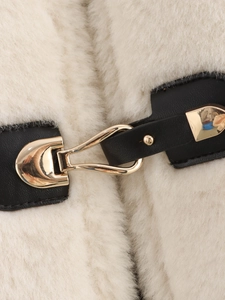 Détail de la veste en fausse fourrure avec brides en cuir noir et boucles dorées