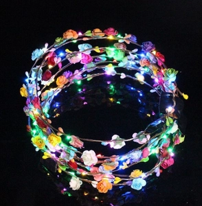 Close-up of vibrant LED flower headbands glowing with multi-color lights in the dark