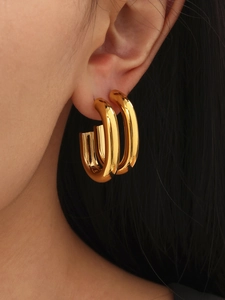 Close-up of elegant gold-plated U-shaped hoop earrings with a high-polished metallic finish