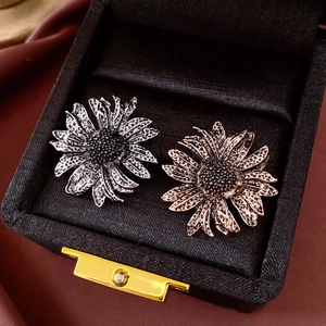 Detailed macro view of vintage flower brooches in gold and silver finish inside a gift box
