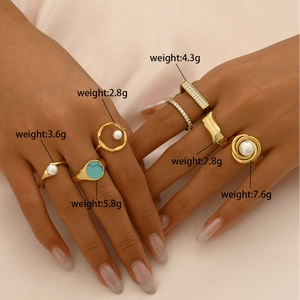 Golden titanium steel ring set with pearls and turquoise on soft pink silk background