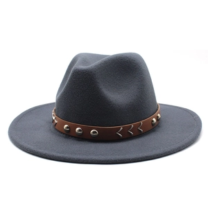 Détail du chapeau fedora en laine grise avec ruban en cuir brun et rivets en métal