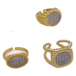 Three gold irregular rings set with cubic zirconia and sunray patterns on white background