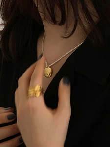 Irregular gold disc pendant necklace on 925 silver chain worn by a female model