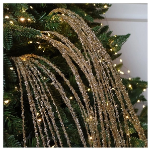 Close-up of sparkling champagne gold sequin tassel ornament on a Christmas tree branch