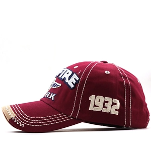 Detailed embroidery of FIRE lettering and distressed brim on burgundy cotton baseball cap
