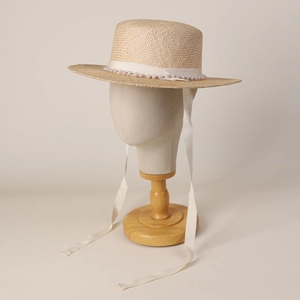 Elegant straw boater hat with white pearl band and long decorative silk ribbons