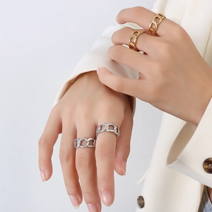 Close-up of gold and silver chain link rings on model hand for a vintage French aesthetic