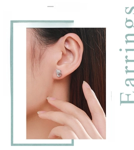 Close-up of s925 silver cat earrings with white zircons worn on a model's ear