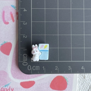 Close-up of mini resin rabbit charm measuring 1.5cm on a scale for DIY crafts