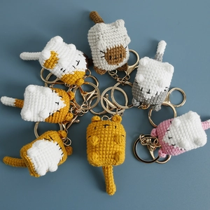 Handmade crochet cat keychains in various colors on a blue background