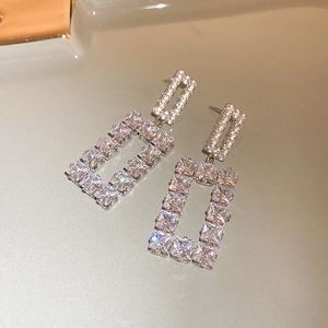 Macro shot of silver geometric square earrings with sparkling pavé cubic zirconia