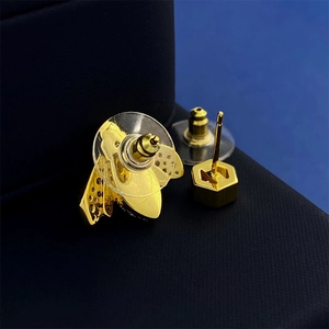 Asymmetric gold bee earrings with sparkling zircons displayed in a jewelry box