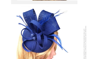 Detail of blue fascinator hat featuring delicate mesh textures and elegant feather accents