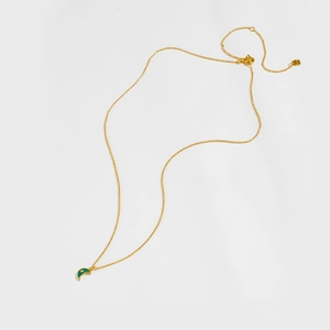 Detailed macro view of S925 sterling silver gold crescent moon necklace with green enamel