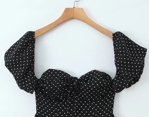 Détail rapproché de la robe rétro à pois avec encolure plissée et manches bouffantes