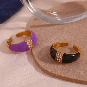 Detailed shot of 18K gold plated rings with purple and black enamel and inset diamonds