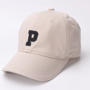 Detail showing the black embroidered letter P on a beige cotton baseball cap with air vents