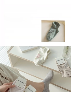 Detailed close-up of minimalist cotton ankle socks with premium brand label and soft texture