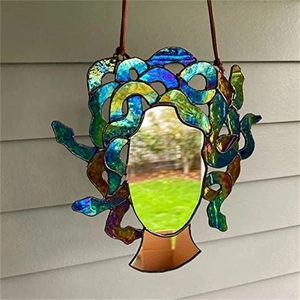 Macro detail of Medusa stained glass hanger featuring iridescent snakes and a mirror face