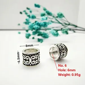 Macro detail of antique silver barrel beads with 6mm large hole and engraved floral patterns