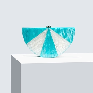 Detail of blue and white marble acrylic evening clutch with radial pattern and gold clasp