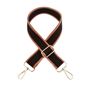 Close-up of adjustable woven shoulder strap with classic pattern and gold metal hooks
