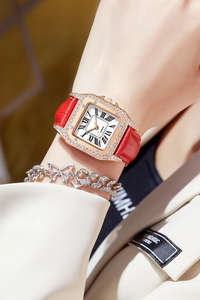Detail of luxury square quartz watch with crystal bezel and red leather strap on wrist