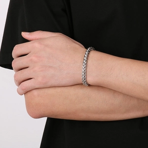 Detailed close-up of a silver stainless steel dragon bone chain bracelet on a wrist