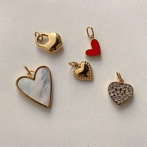 Detailed close-up of heart pendants in gold, red, and mother of pearl finishes