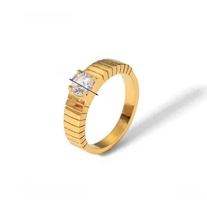 Detail of gold-plated wide ring with grooved texture and 5mm round zircon inlay