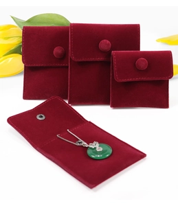 Detailed view of burgundy velvet jewelry pouches with snap buttons in multiple sizes