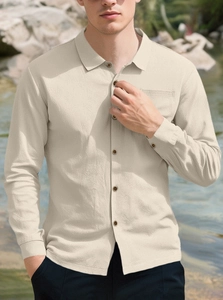 Detailed close-up of beige men's linen beach shirt showing textured waffle fabric and pocket