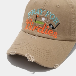 Detail of tan distressed baseball cap with colorful golf themed letter embroidery