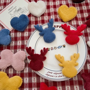 Plush Christmas ornaments in reindeer and heart shapes on a festive checkered backdrop