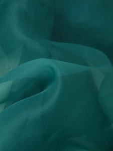 Makroaufnahme von elegantem pfauengrünem Organza-Stoff mit seidiger Wellenstruktur
