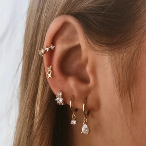Close-up of gold S925 sterling silver star studs and crystal cartilage hoop earring set
