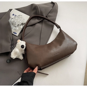 Deep brown crescent PU leather shoulder bag with plush bear charm and sleek logo