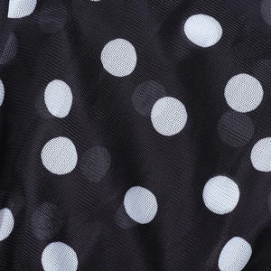 Nahaufnahme von schwarzem Netzgewebe mit weißen Punkten auf einem Sommerkleid