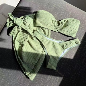 Detail of light green bikini set showing ripple texture fabric and gold ring hardware